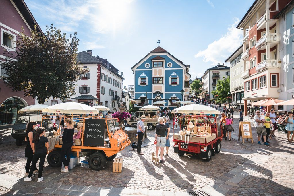 Markets in the town of Ortisei, one of the best palaces to spend a cultured family summer holiday in the Dolomites.