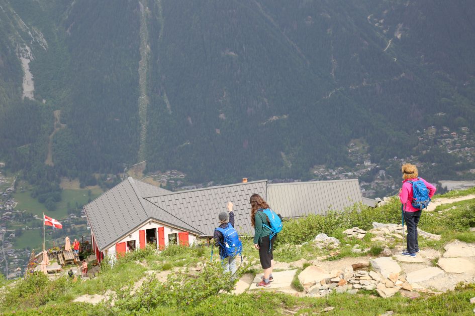 Hikers pointing and looking out to the views from Refuge du Plan de Aiguille in Chamonix.