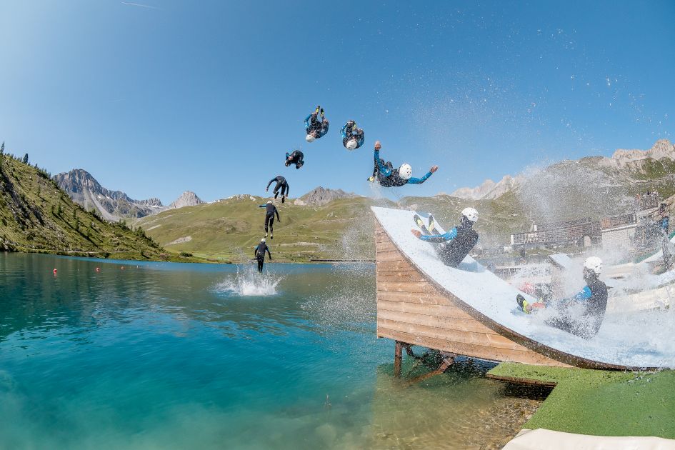 Snapshots of a man sliding into the air before falling into a mountain lake.