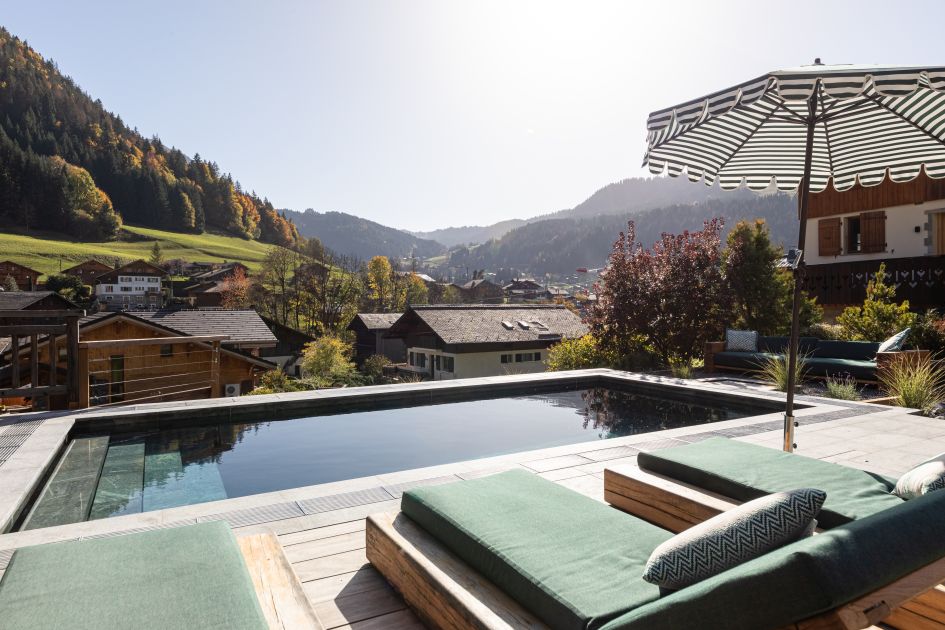 External of Chalet Doyen showcasing the outdoor swimming pool and summer mountain views.