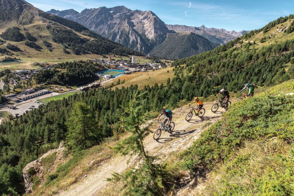 Biking on trails in the mountains above Sestriere in summer, the alpine resort in Italy which can be seen in the background.