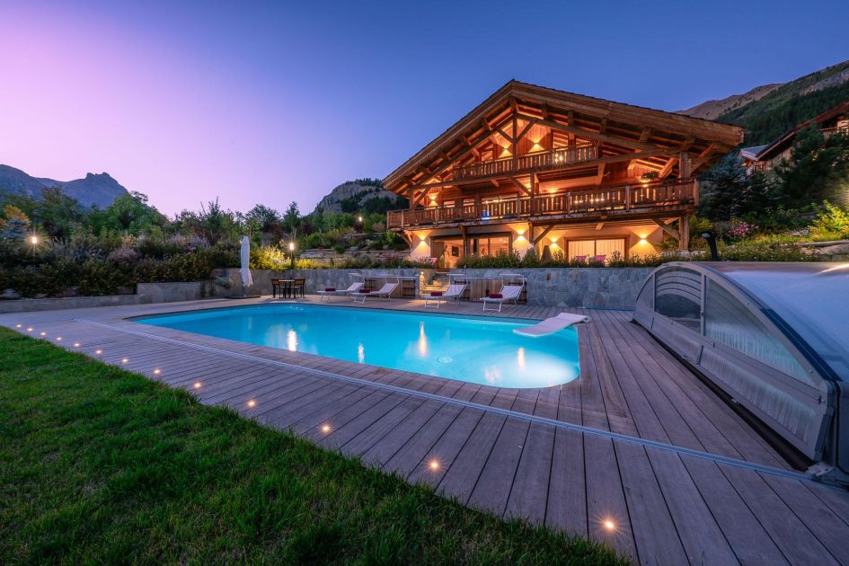 External of Chalet Le Tabuc showing the outdoor swimming pool and scenic surroundings.