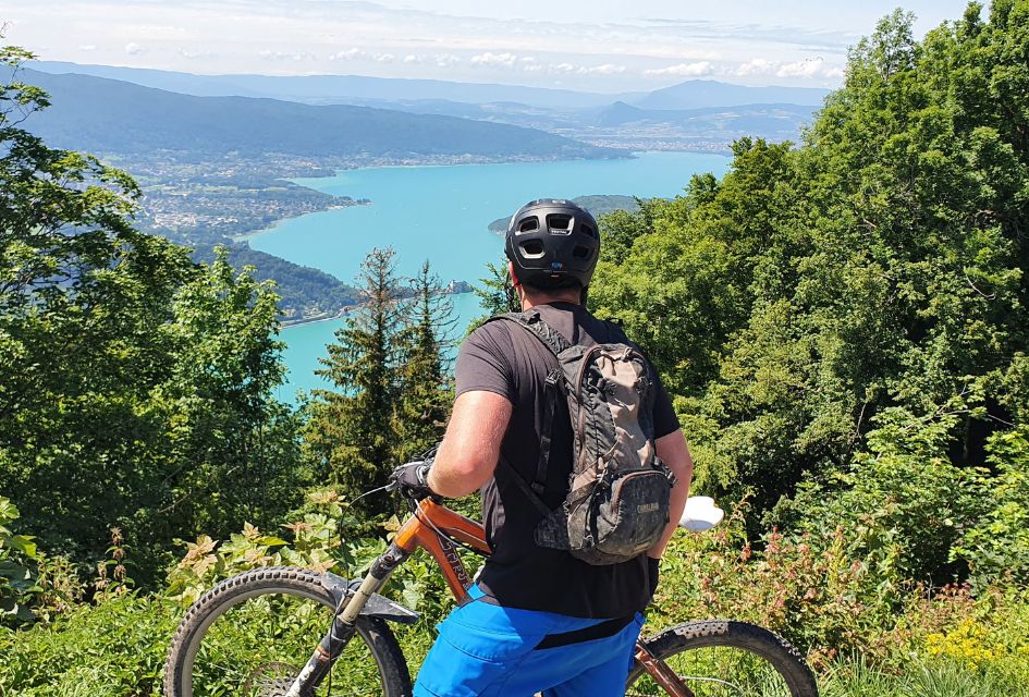 A man with a bike overlooks one of the lakes in Morzine while enjoying his eco-conscious summer mountain holidays.